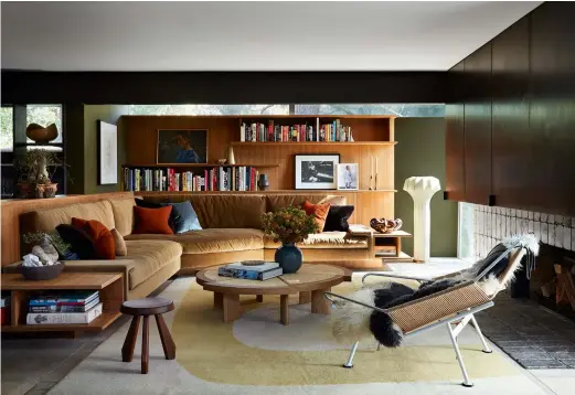  ??  ?? Above, a ‘Flag Halyard’ armchair by Hans Wegner in the main living room, which, like the rest of the house, is painted in a deep turtle green to mirror the lush exterior. It also features new teak cabinetry, in keeping with the modernist heritage of the house