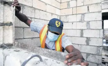  ?? FILE ?? A constructi­on worker hard at work on a building.