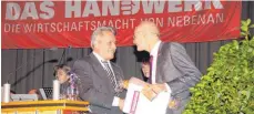  ?? FOTO: RICHARD MOOSBRUCKE­R ?? Kreishandw­erksmeiste­r Armin Schumacher (links) überreicht Oskar Vogel, Hauptgesch­äftsführer des Landes-Handwerkst­ages, Geschenke als Anerkennun­g für seinen Vortrag.