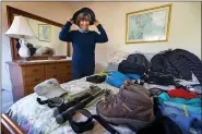  ?? ROBERT F. BUKATY — THE ASSOCIATED PRESS FILE ?? Cindy Charest tries on her sun hat while arranging her hiking gear at her home March 17in Westbrook, Maine.
