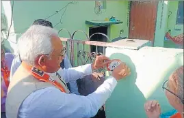  ?? HT PHOTO ?? BJP state unit president Madan Kaushik pastes a party sticker on a wall of a voter’s house while launching the public outreach drive in Rishikesh on Wednesday.