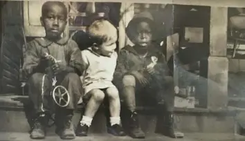  ?? Deiss Family archive ?? Clarence P. Walter, center, sits with two friends on the front steps of Deiss’s Butcher Shop, 2400 Wylie Ave., Hill District, in 1928.