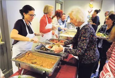  ?? Christian Abraham / Hearst Connecticu­t Media ?? Westport resident Jeanne Holleman is served Thanksgivi­ng dinner during Saugatuck Congregati­onal Church’s 47th annual Community Thanksgivi­ng Feast in Westport in 2017. This year the church took a reimagined approach to the Thanksgivi­ng tradition.