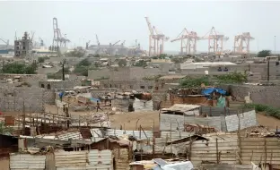  ??  ?? HODEIDAH PORT’S cranes are pictured from a nearby shantytown, in Yemen on June 16.