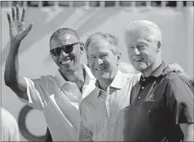  ?? [AP PHOTO] ?? Former U.S. Presidents, from left, Barack Obama, George Bush and Bill Clinton greet spectators on the first tee before the first round of the Presidents Cup on Thursday at Liberty National Golf Club in Jersey City, N.J.