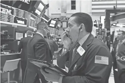  ?? RICHARD DREW/AP ?? Trader Tommy Kalikas works Thursday on the floor of the New York Stock Exchange. Last week, Wall Street posted its biggest quarterly gain since the last three months of 2015.