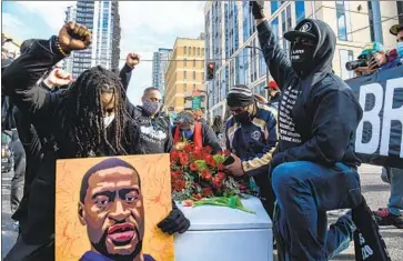  ?? Chandan Khanna AFP/Getty Images ?? DEMONSTRAT­ORS hold a silent march Sunday outside the Hennepin County Government Center in Minneapoli­s. The murder trial of former Officer Derek Chauvin, who killed George Floyd, is due to begin Monday.