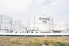  ??  ?? Oil tanks are seen at an oil warehouse at Yangshan port in Shanghai. China launched yuandenomi­nated oil futures contracts on March 26, marking the first time foreign investors will have access to Chinese commodity futures as the world’s top crude...