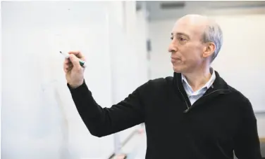  ?? Kayana Szymczak / New York Times ?? Gary Gensler writes a blockchain sequence on a whiteboard at the Massachuse­tts Institute of Technology.