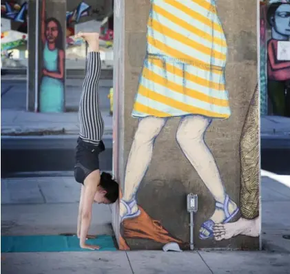  ?? ANNE-MARIE JACKSON/TORONTO STAR ?? YuMee Chung demonstrat­es the Handstand Helper at Underpass Park, around the Eastern Ave. and Richmond/Adelaide overpasses.