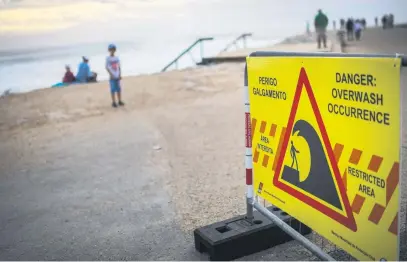  ?? Picture: AFP ?? HIGH WATER. A warning sign reading ‘Danger: overwash occurrence’ at Costa da Caparica, near Lisbon, on Saturday. Portugal placed most of the country on red alert because of storms.