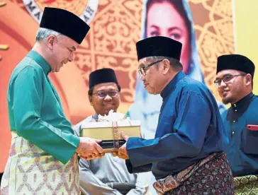  ?? — Bernama ?? All smiles: Sultan Nazrin (left) presenting the Tokoh Ar-Ridzuan award to Lat during the Maal Hijrah celebratio­n at the Ipoh Convention Centre.