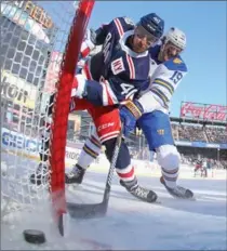  ?? BRUCE BENNETT, GETTY IMAGES ?? Michael Grabner, left, of New York, scores a first-period goal against the Buffalo Sabres in the Outdoor Classic. Rangers won in OT 3-2.