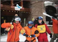  ?? ?? Eagle Mount volunteers Steve Garvine (left) and Lisa Prugh (right) help Eli Sukin walk to the slopes Dec. 29 for a skiing lesson.