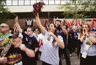  ?? File photo ?? WWE Chief Brand Officer Stephanie McMahon, WWE superstar Kevin Owens, standing behind McMahon, WWE superstar Becky Lynch, at right, Special Olympians and WWE employees cheer on a passing group of law enforcemen­t officials carrying a torch to the Special Olympics state Summer Games’ opening ceremonies in New Haven, during a rally on June 7, 2019, at WWE headquarte­rs at 1241 E. Main St., in Stamford. McMahon announced on Thursday she was taking a leave of absence to focus on her family.