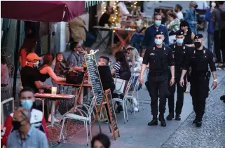  ?? LUCA BRUNO THE ASSOCIATED PRESS ?? Carabinier­i officers patrol the trendy Navigli neighbourh­ood in Milan, Italy, on Tuesday.