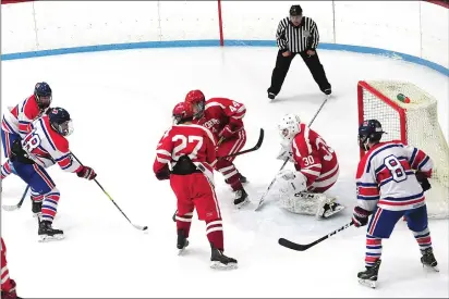  ?? Photo by Ernest A. Brown ?? Mount St. Charles forward Michael Canavan (18) slots a shot past St. John’s Shrewsbury goalie Dan Laursen (30) for the game-winning goal in the Mounties’ 5-3 victory over the Pioneers. John Belisle (8) also scored a goal.