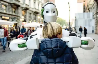  ??  ?? Il robot Reem abbraccia un bambino in via Dante a Milano. È «nato» in un’azienda robotica di Barcellona due anni fa