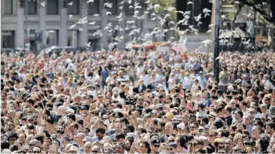  ??  ?? Crowds gather in Barcelona for a minute of silence in memory of the terrorist attack victims in Las Ramblas, Barcelona. Spanish police on Friday shot and killed five people who were connected to the Barcelona van attack that killed 13,