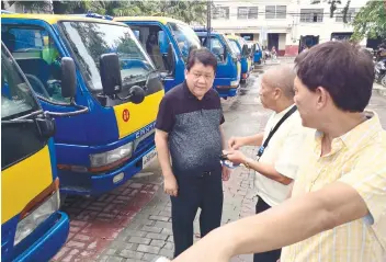  ?? SUNSTAR FOTO / ARNI ACLAO ?? ADDITIONAL TRUCKS. Cebu City Mayor Tomas Osmeña (left), Councilor Eugenio Gabuya Jr. (right), and DPS chief Roberto Cabarrubia­s (center) inspect the 21 vehicles from Pamocor that were parked at the Plaza Sugbo grounds.