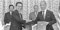  ??  ?? Muhyiddin (right) exchanges the signed MoU with Awang Abu Bakar at Perdana Putra yesterday, witnessed by Sultan Hassanal Bolkiah (left) and Dr Mahathir.