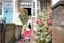  ?? — Reuters ?? A resident leaves an envelope with a completed Covid-19 home test kit to be picked up by a volunteer during a door-to-door tests delivery in an effort to halt the new SARS-COV-2 variant’s spread, in Ealing, West London, on Wednesday.