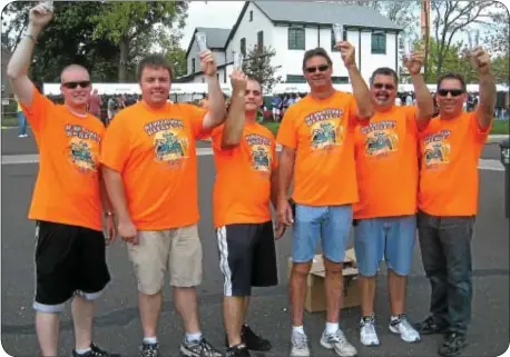  ?? Photograph by Ann Cole ?? Newtownís volunteer firefighte­rs get ready for the start of their third Beer Fest. Fire Associatio­n President Michael Errico, last man on the right, expressed his thanks for the people who came out to support the fire associatio­n at the event. ìThank...