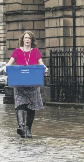  ??  ?? 0 Edinburgh Council staff with Polling Place signs, ballot boxes