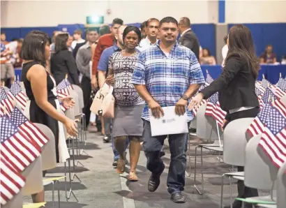  ?? PHOTOS BY MICHAEL CHOW/THE REPUBLIC ?? Citizenshi­p candidates enter the South Mountain Community College gymnasium on Tuesday. The ceremony at the Phoenix campus ended with 151 people being sworn in as new citizens of the United States. They were among 15,000 sworn in nationwide on the...