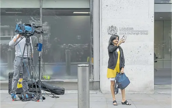  ?? BLOOMBERG ?? Recuerdo. Una turista se toma una selfie, ayer, a las puertas del London Stock Exchange, el cuartel general de la Bolsa en Londres.