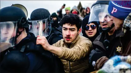  ?? Picture: Jake May/the Flint Journal-via AP ?? „ Protesters try to block police as they escort supporters of white supremacis­t Richard Spencer during his visit to Michigan State University in East Lansing, Michigan, where he was due to give a speech to white nationalis­t supporters.