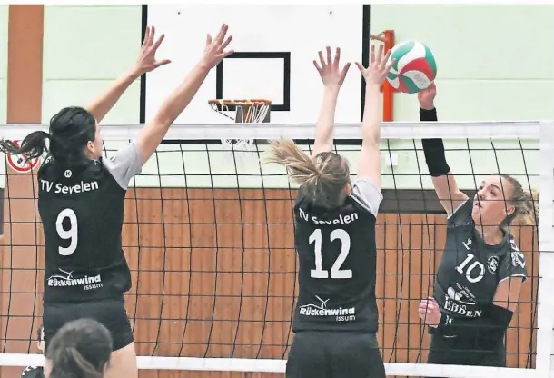  ?? RP-FOTO: KLAUS-DIETER STADE ?? Carolin Sicker (r.) von der SV Bedburg-Hau versucht, den Sevelener Block mit Andrea Kiesewette­r (l.) und Anna Neyenhuys zu überwinden.