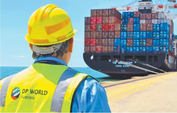  ?? ?? A worker looks at a container ship docked at the DP World container berth at the Port of Brisbane. Picture: Eric Taylor/Bloomberg