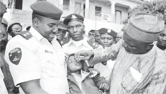  ?? PHOTO ?? Chairman, Taxi Section, Kawo Motor Park, Mr Adamu Indah (right), immunising a child at the launch of ‘Transit Immunisati­on’ in Kaduna yesterday.