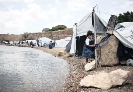  ??  ?? PLIGHT OF REFUGEES: A Syrian child walks on a beach where refugees and other migrants live in makeshift tents near the Souda refugee camp on Chios Island. On World Refugee Day, more than 60 000 refugees and migrants are still stranded in Greece...