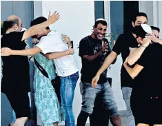  ??  ?? A women’s rights activist, right, protests in support of a British teenager who was found guilty yesterday of lying that she was gang-raped by a group of Israelis in Cyprus. Left, Israeli teenagers are embraced by relatives after being released by police on July 28