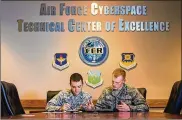  ?? U.S. AIR FORCE PHOTO/BRUCE LAMBERT ?? Capt. Seth Martin (left) and 2nd Lt. Landon Tomcho earned master’s degrees in cyber operations and computer science from the Air Force Institute of Technology in 2019. AFIT has been redesignat­ed as a National Center of Academic Excellence in Cyber Defense Research.