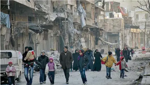  ?? — AFP ?? Syrian residents fleeing the violence in the eastern rebel-held parts of Aleppo evacuate from their neighbourh­oods through the Bab al Hadid district after it was seized by the government forces on Wednesday.