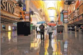  ?? K.M. Cannon Las Vegas Review-journal @Kmcannonph­oto ?? People walk in the rain through the Fremont Street Experience. The Las Vegas Valley had not seen widespread rainfall since Sept. 23.