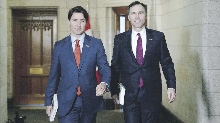  ?? SEAN KILPATRICK / THE CANADIAN PRESS ?? Prime Minister Justin Trudeau and Finance Minister Bill Morneau, right, make their way to deliver the federal budget in Ottawa last March.