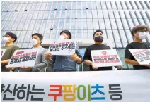  ?? Yonhap ?? Members of civic groups, including People’s Solidarity for Participat­ory Democracy, hold signs calling on food delivery app operators to come up with proper measures to protect restaurant owners from malicious reviews by consumers, in front of Coupang’s headquarte­rs, Tuesday. The e-commerce company operates the food delivery platform, Coupang Eats.