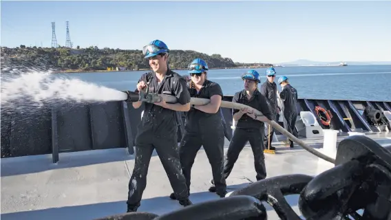  ?? PHOTOS BY LAURA MORTON ?? Above: Ship operations students use a hose to spray down the deck of the Golden Bear training ship at California Maritime Academy in Vallejo. Below left: The California State University school is the only degree-granting maritime university in the...