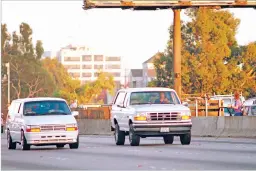  ?? LOIS BERNSTEIN/ASSOCIATED PRESS FILE PHOTO ?? Al Cowlings, with O.J. Simpson hiding, drives a white Ford Bronco as they lead police on a two-county chase along Interstate 405 northbound toward towards Simpson’s home on June 17, 1994, in Los Angeles. The model was discontinu­ed two years later.