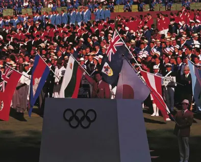  ??  ?? Flag day Japanese gymnast Takashi Ono reads the Olympic Oath during the opening ceremony of the 1964 Tokyo Games – an event that was painstakin­gly planned and designed to overhaul Japan’s image at home and abroad