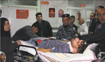  ?? Shwan Mohammed / AFP / Getty Images ?? Rescue workers at a hospital in Sulaymaniy­ah, Iraq, assist a man injured in the 7.3-magnitude earthquake. The temblor was centered 19 miles southwest of the Iraqi city of Halabja.