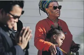  ?? Luis Sinco Los Angeles Times ?? RELATIVES and neighbors of shooting victims attend a memorial ceremony at a home in Long Beach after an Oct. 29 shooting during a party killed three people.