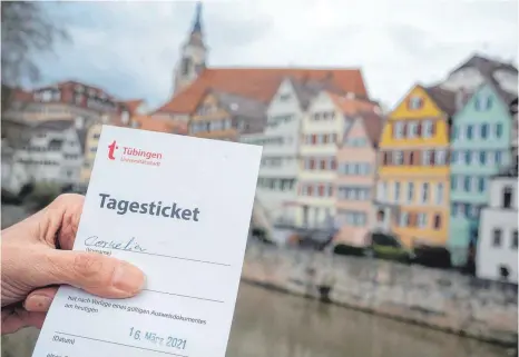  ?? FOTO: SEBASTIAN GOLLNOW/DPA ?? Eine Frau zeigt in Tübingen ihr „Tagesticke­t“, das aufgrund eines negativen Testergebn­isses bei einem Corona-Schnelltes­t ausgestell­t wurde. Das Ticket öffnet ihr buchstäbli­ch wieder viele Türen in der Stadt.