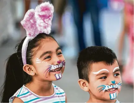  ?? Brett Coomer / Houston Chronicle ?? Emily Hernandez and her brother, Israel, don face paint during the annual Easter in the Gardens at Moody Gardens on Sunday in Galveston. Steve Smith, a former Houston news anchor and now the “voice of Moody Gardens,” emceed the event.