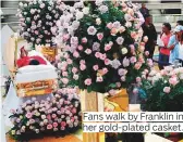  ??  ?? Fans walk by Franklin in her gold-plated casket.