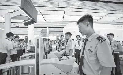  ??  ?? Passengers and airline crew can finish boarding procedures with facial recognitio­n systems at Beijing’s Daxing airport. — Ti Gong
